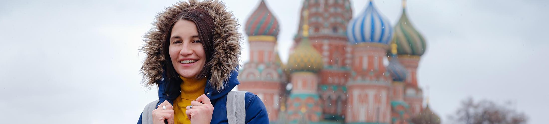 Woman in jacket in front of castle.